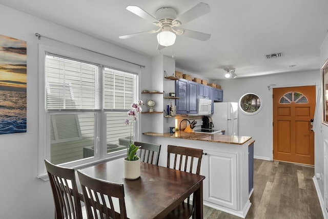 dining area with dark wood finished floors, visible vents, baseboards, and ceiling fan