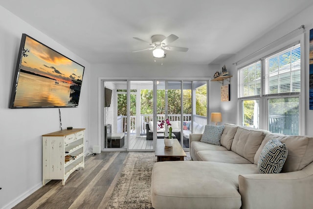 living room with baseboards, wood finished floors, and ceiling fan