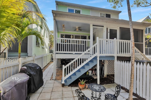 back of property featuring stairway, a porch, and fence