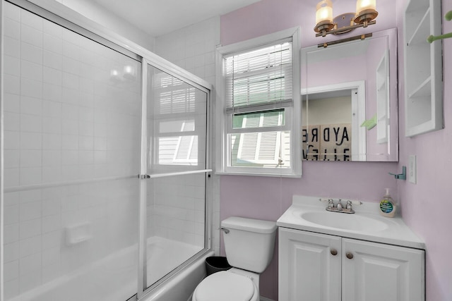 full bath featuring combined bath / shower with glass door, toilet, and vanity