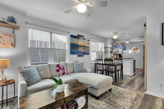 living area featuring baseboards, ceiling fan, and wood finished floors