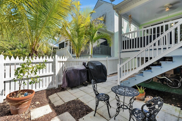 view of patio / terrace featuring area for grilling, stairs, and fence