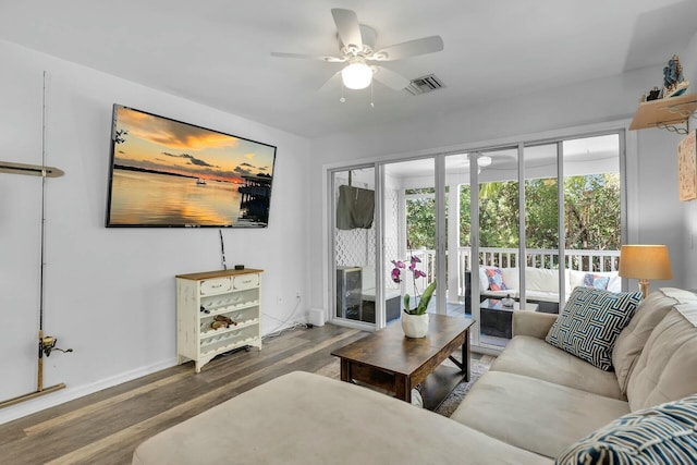 living room with visible vents, wood finished floors, baseboards, and ceiling fan