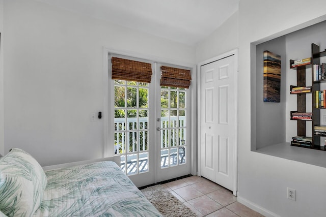 bedroom with access to exterior, light tile patterned floors, french doors, and baseboards