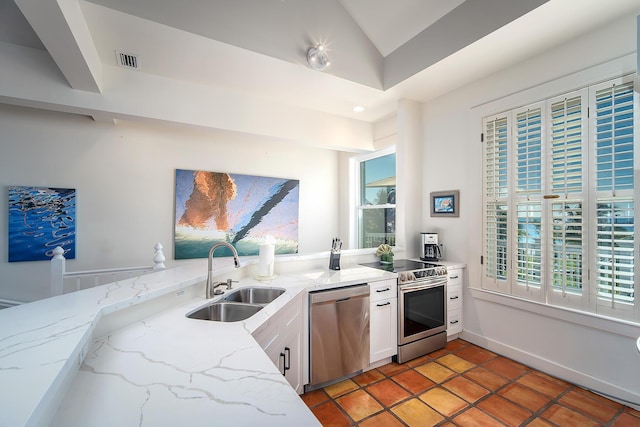 kitchen with light stone counters, sink, stainless steel appliances, and white cabinets