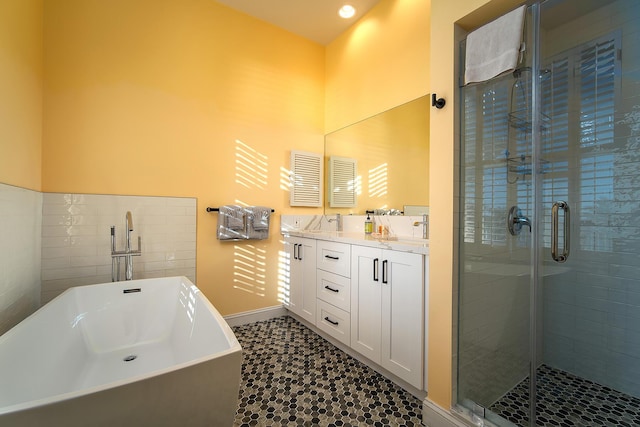 bathroom featuring shower with separate bathtub and sink