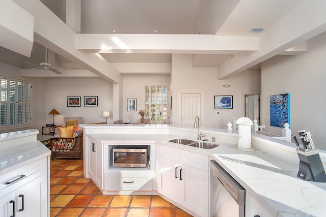 kitchen featuring white cabinetry, appliances with stainless steel finishes, light stone countertops, and sink