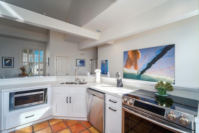 kitchen featuring sink, white cabinetry, light stone counters, beamed ceiling, and stainless steel appliances