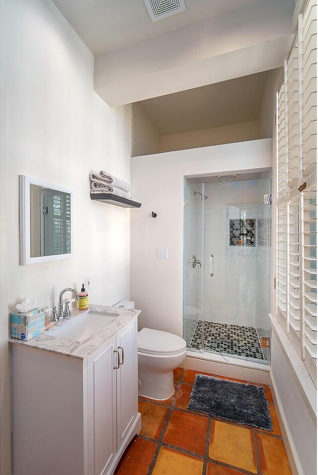 bathroom with vanity, tile patterned floors, a shower with door, and toilet