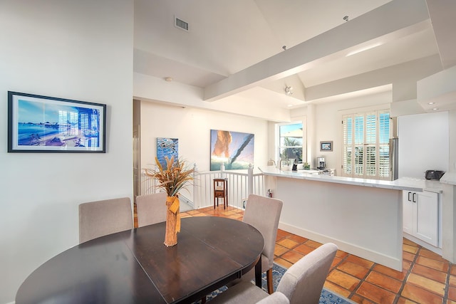 tiled dining room with beam ceiling