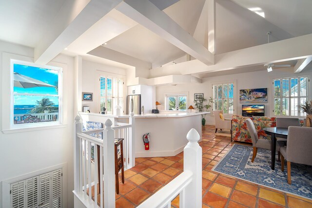 tiled dining space with lofted ceiling with beams