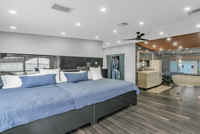 bedroom featuring a walk in closet and dark hardwood / wood-style floors