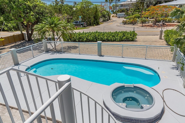 view of swimming pool with an in ground hot tub