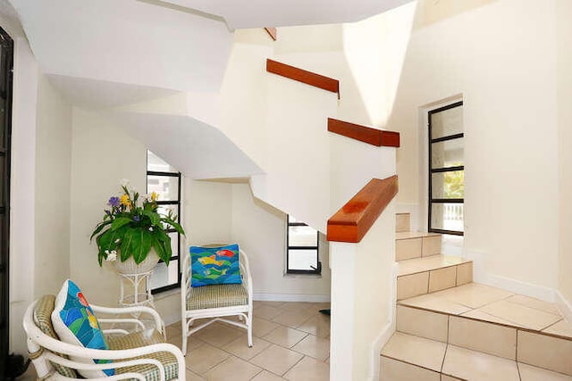 staircase with tile patterned floors and vaulted ceiling