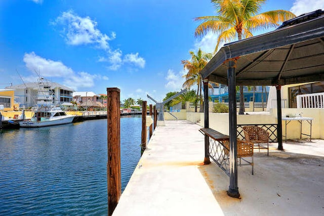 view of dock with a gazebo and a water view