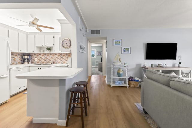 1101 W Ocean Dr Unit 29, Key Colony, FL 33051 - kitchen with white appliances, a kitchen bar, white cabinets, light countertops, and a sink