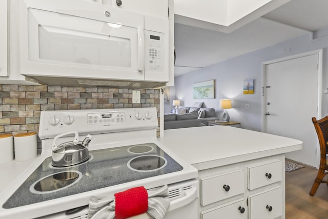 1101 W Ocean Dr Unit 29, Key Colony, FL 33051 - kitchen with white appliances, white cabinets, backsplash, light countertops, and a peninsula