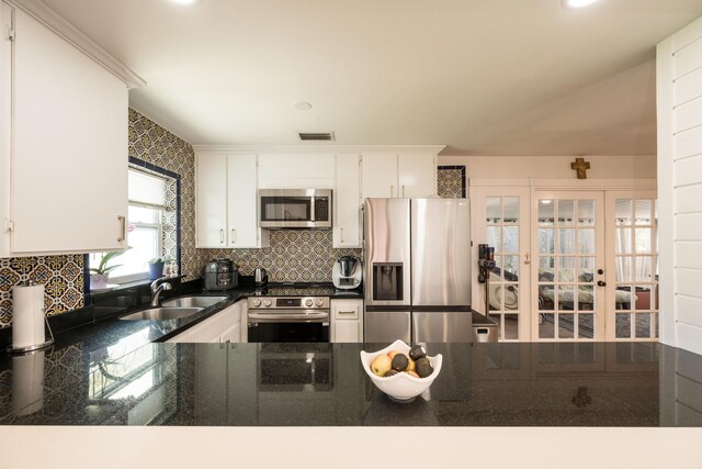 1205 11th St, Key West, FL 33040 - kitchen with tasteful backsplash, appliances with stainless steel finishes, a sink, dark countertops, and french doors