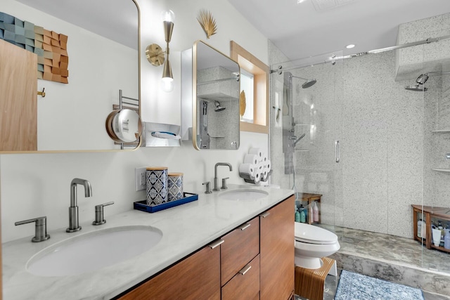 full bathroom featuring double vanity, a shower stall, toilet, and a sink