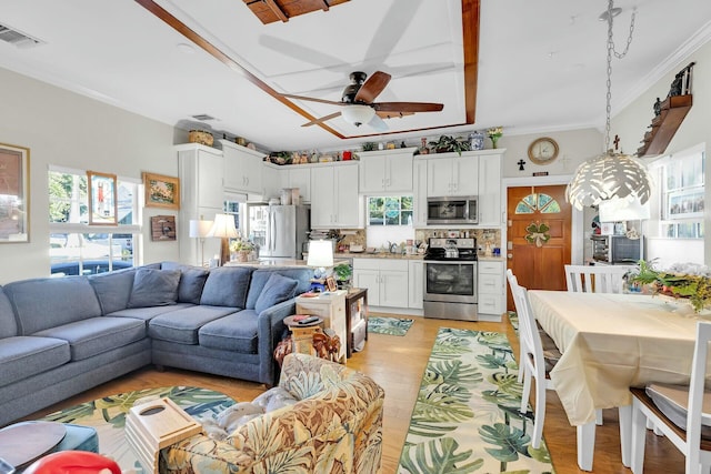 living area with ceiling fan, light wood-type flooring, visible vents, and crown molding