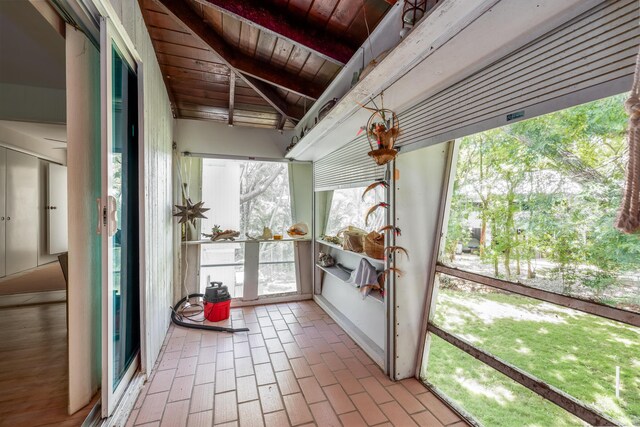 unfurnished sunroom featuring wooden ceiling and beam ceiling