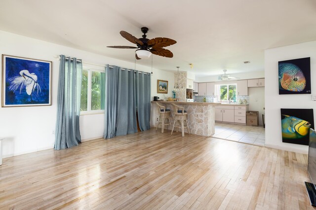 living room with ceiling fan and light wood-type flooring