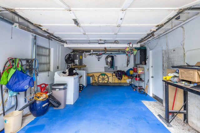 garage featuring water heater and washer and clothes dryer