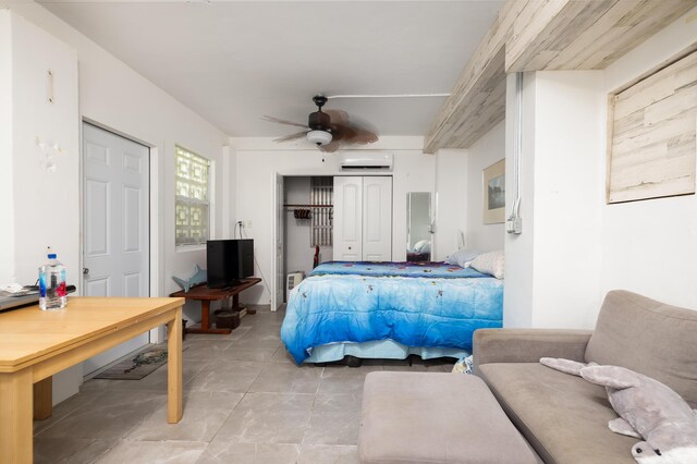 bedroom featuring a wall mounted air conditioner, ceiling fan, and light tile patterned floors