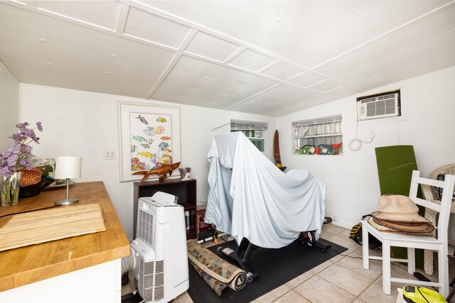 miscellaneous room with light tile patterned floors and a wall unit AC