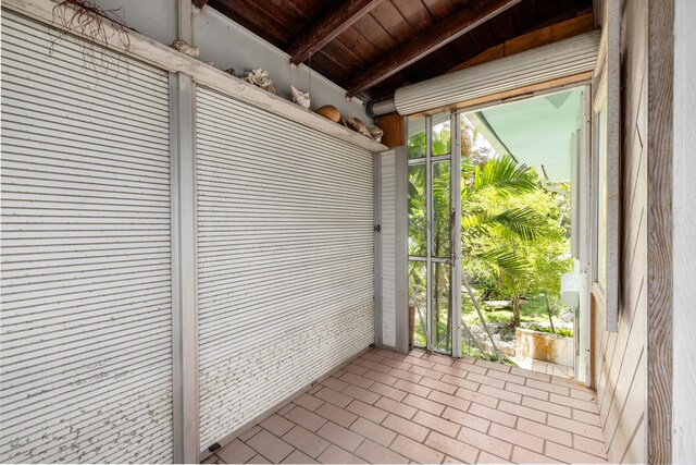 unfurnished sunroom with beam ceiling