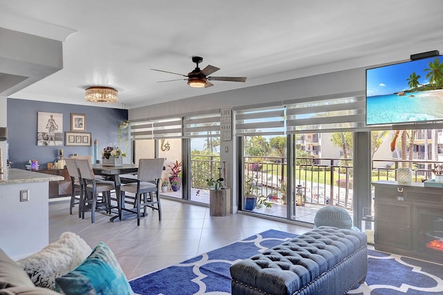 living room featuring light tile patterned floors, ornamental molding, and ceiling fan