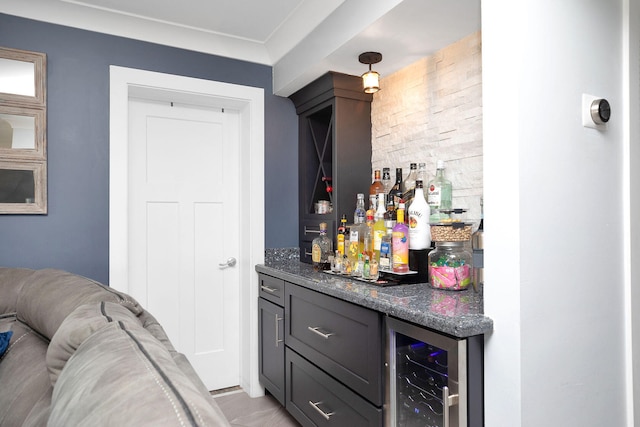 bar with wine cooler and dark stone countertops