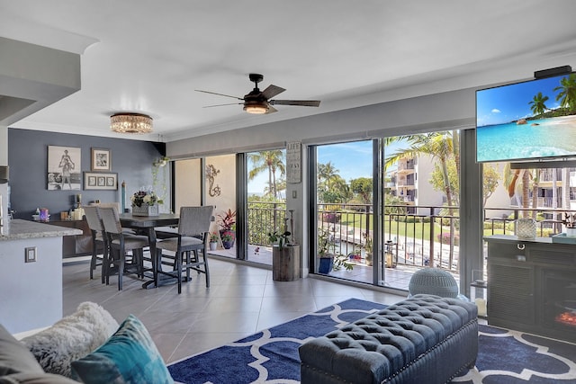 living room with crown molding, ceiling fan, and light tile patterned floors