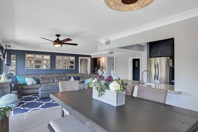 dining space featuring crown molding, sink, and ceiling fan