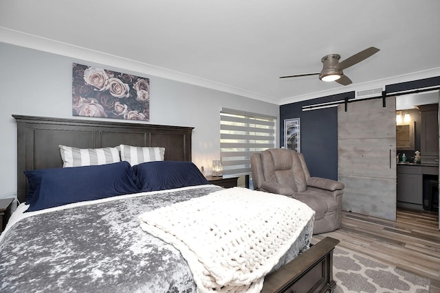 bedroom featuring hardwood / wood-style flooring, ornamental molding, a barn door, and ceiling fan