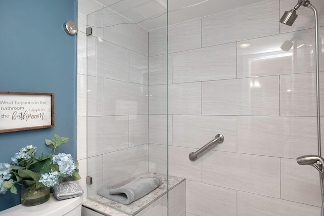 bathroom with toilet and a tile shower