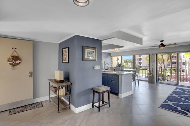 bar with sink, light tile patterned floors, blue cabinetry, ceiling fan, and ornamental molding