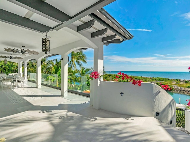 view of patio with ceiling fan and a water view