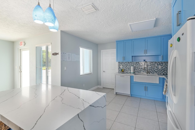 kitchen featuring blue cabinets, white appliances, visible vents, and a sink