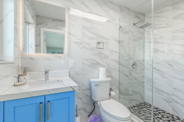 bathroom featuring tasteful backsplash, toilet, vanity, a shower stall, and tile walls