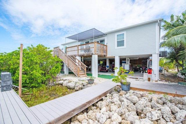 rear view of house featuring a wooden deck and a patio