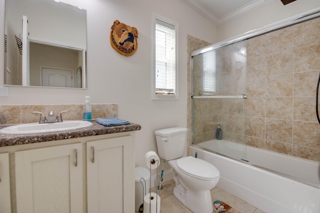 full bathroom featuring toilet, crown molding, shower / bath combination with glass door, vanity, and tile patterned flooring