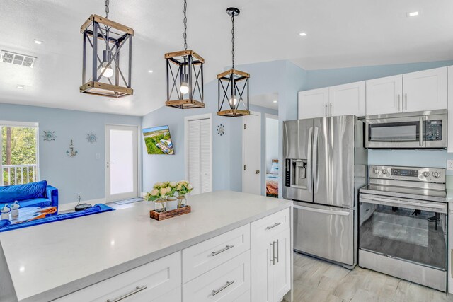 29012 Bigonia Dr, Big Pine, FL 33043 - kitchen featuring stainless steel appliances, light countertops, lofted ceiling, white cabinets, and decorative light fixtures
