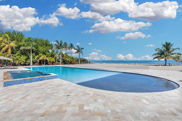 view of swimming pool featuring a patio area, an in ground hot tub, and a water view