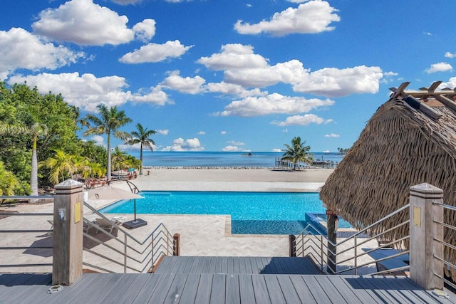 view of pool featuring a view of the beach and a water view