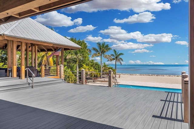 deck featuring a water view and a beach view