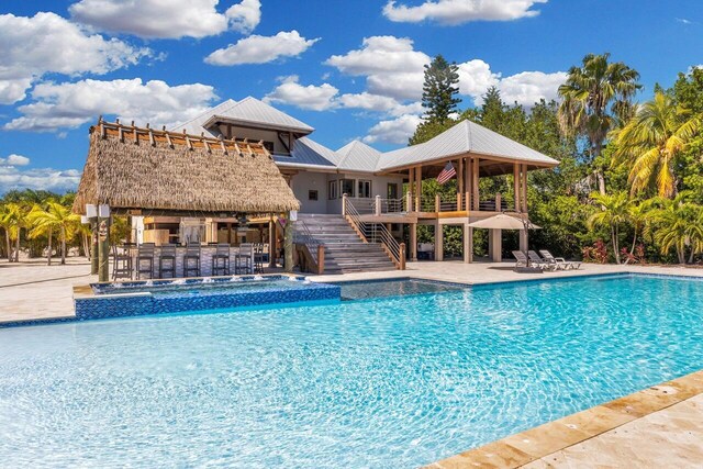 view of swimming pool with a patio and a bar