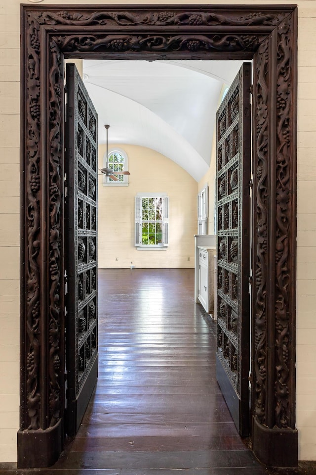 corridor with lofted ceiling and dark hardwood / wood-style floors