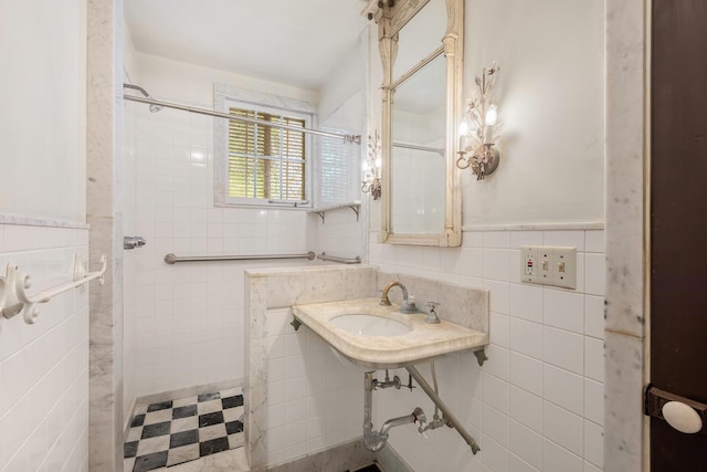 bathroom with walk in shower, sink, and tile walls