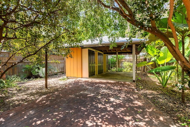 view of patio with a carport and an outbuilding